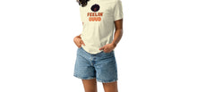 Load image into Gallery viewer, A woman wearing a pale yellow t-shirt with text, 'FEELIN GUUD with fluffy afro design on a white background