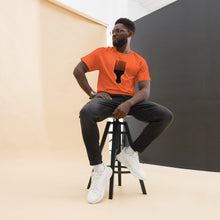 Load image into Gallery viewer, Man wearing a orange t-shirt with a black afro pick design on a white background