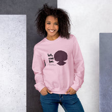 Load image into Gallery viewer, A woman wearing a light pink sweatshirt with text 'let, me be. FEARLESS BLACK WOMAN' and a silhouette of a woman's head.
