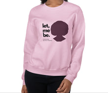 Load image into Gallery viewer, A woman wearing a light-pink sweatshirt with text 'let, me be. FEARLESS BLACK WOMAN' and a silhouette of a woman's head.
