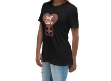 Load image into Gallery viewer, Woman wearing a black t-shirt with a heart and 'Self Care' text design on a white background