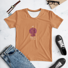 Load image into Gallery viewer, Caramel t-shirt with purple graphic design on a white surface with jeans, sneakers, and glasses.