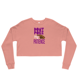 Pink long-sleeve crop top with purple text, 'DON"T POKE MY PATIENCE' and brown hand graphic on a white background