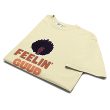 Load image into Gallery viewer, Pale yellow t-shirt with graphic of a person with an afro and &#39;FEELIN GUUD&#39; text on a white background
