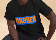 Load image into Gallery viewer, Man wearing a black t-shirt with 'GARDEN' printed on it against a beige background
